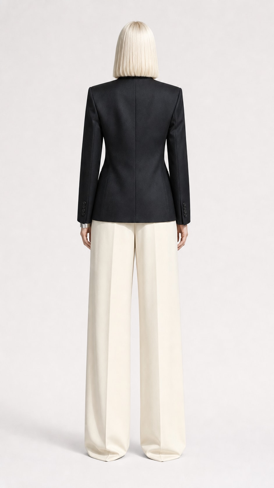 Fictional blonde fashion model in sculptural tailoring inside a concrete studio